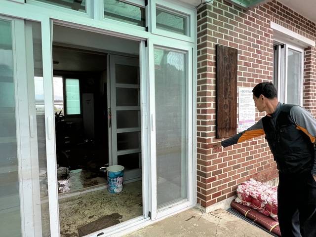 이강락 양산마을 이장이 노인정 샷시 문에 남아있는 물이 차올랐던 지난 밤의 흔적을 손가락으로 가리키고 있다.