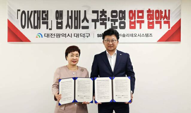 최충규 대전 대덕구청장(오른쪽)과 김숙희 솔리데오시스템즈 대표가 20일 구민 사랑방에서 'OK대덕' 앱 서비스 구축을 위한 협약을 맺고 있다. (사진=대덕구 제공)