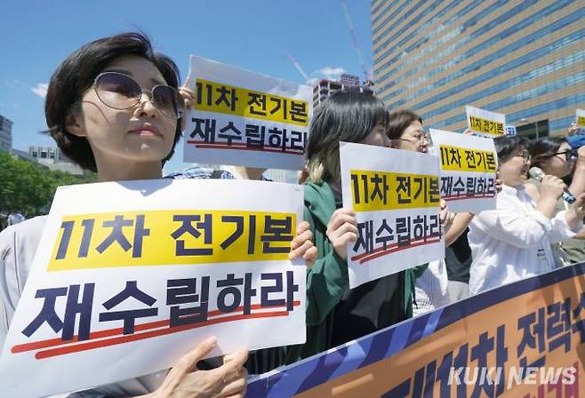 민주노총과 기후위기비상행동, 기후정의동맹 등 시민사회단체 활동가 등이 3일 오후 서울 종로구 세종대로 광화문 광장에서 가진 제11차 전력수급기본계획 실무안 재수립 촉구 공동 기자회견에서 손팻말을 들고 있다.