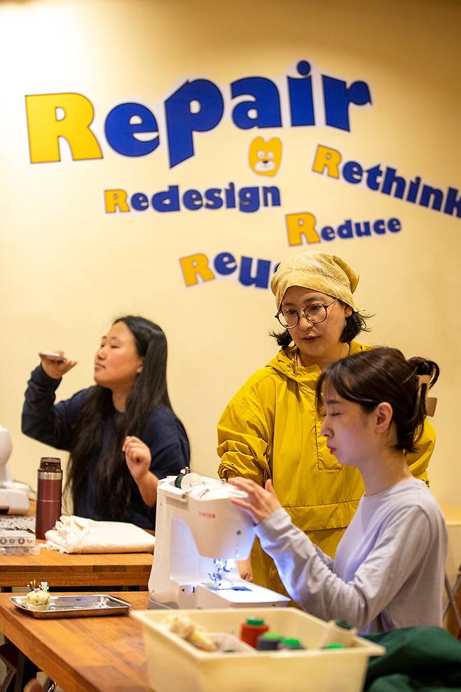 워크숍이 열리지 않는 날에도 언제든지 수리·수선 작업을 할 수 있다. 5월23일 ‘곰손지기’ 자두씨(가운데)가 재봉틀 수선 번개 모임에 온 사람들을 돕고 있다. ⓒ시사IN 신선영