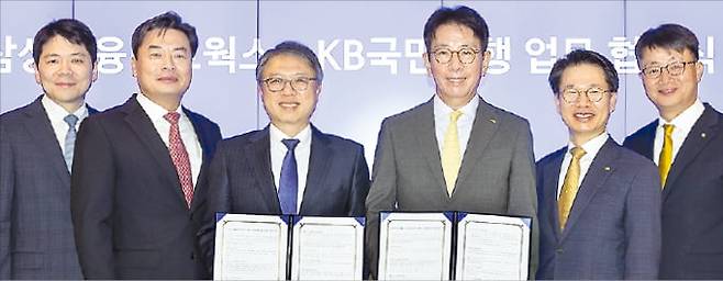 삼성금융네트웍스와 국민은행이 4일 서울 태평로 삼성 본관에서 상호 협력을 위한 업무협약을 맺었다. 김대환 삼성카드 사장(왼쪽 세 번째)과 이재근 국민은행장(네 번째)이 삼성생명·화재·카드·증권, 국민은행 임원들과 함께 협약서를 들어 보이고 있다. 삼성금융 제공