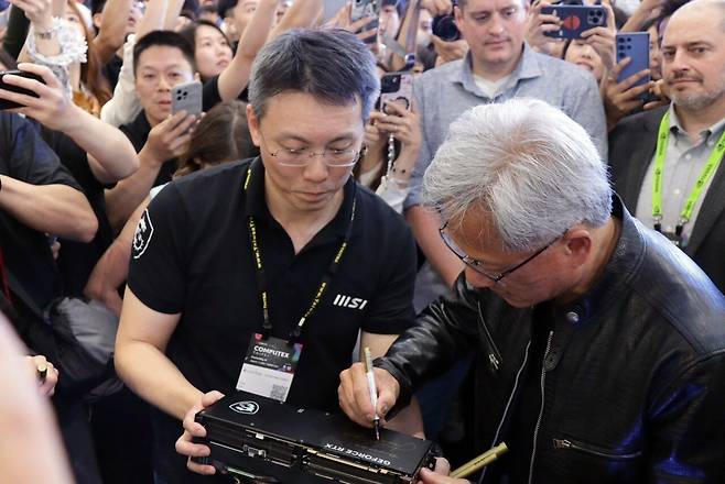 ▲ 엔비디아의 아버지, 젠슨 황이 직접 MSI 부스에 방문해 사인을 해주고 있는 모습