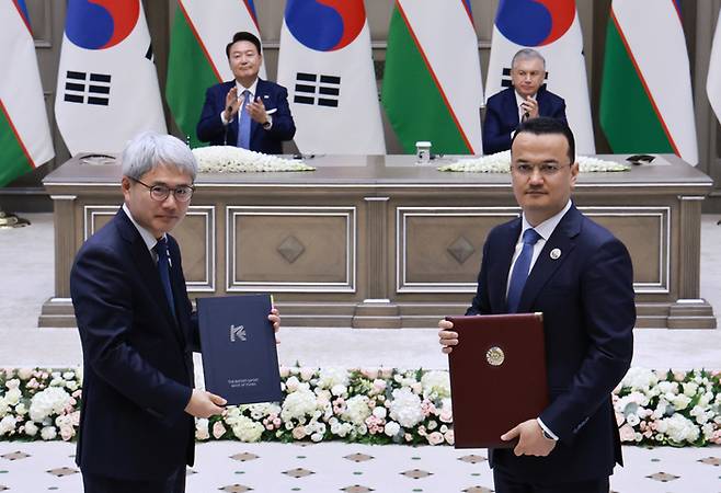 윤희성 한국수출입은행장과 라지즈 쿠드라토프 우즈베키스탄 투자산업통상부 장관이 14일(현지시간) 우즈베키스탄 타슈켄트 대통령궁에서 열린 한·우즈베키스탄 협정 및 양해각서(MOU) 서명식에서 기념촬영을 하고 있다. 연합뉴스