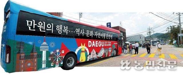 대구시티투어버스인 ‘군위군 돋보기 투어’ 참가자들이 버스에 탑승하고 있다. 사진=김병진 기자