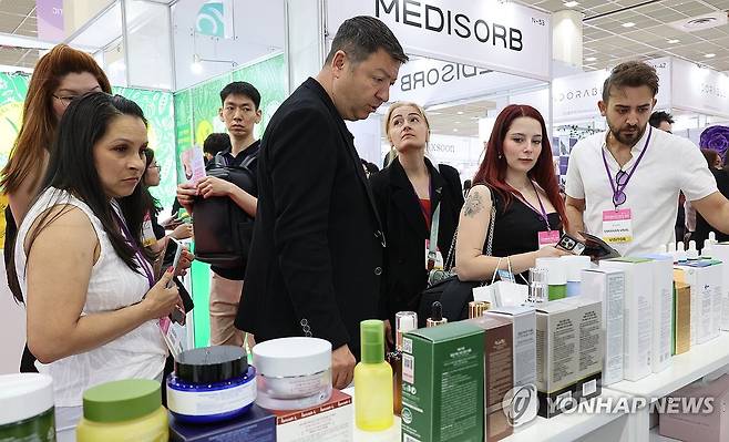 K뷰티 인기 (서울=연합뉴스) 한상균 기자 = 29일 코엑스에서 열린 서울국제화장품미용,건강산업 박람회에서 외국인들이 전시 상품을 보고 있다. 2024.5.29 xyz@yna.co.kr