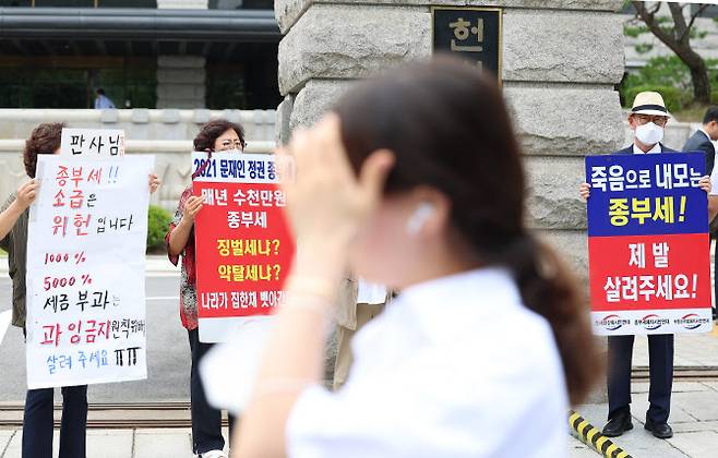 30일 오후 서울 종로구 헌법재판소 앞에서 시민들이 종부세 규탄 피켓을 들고 서 있다.(사진=연합뉴스)