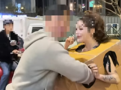 지난해 10월 한 여성이 알몸에 상자만 걸친 채 서울 압구정, 홍대 등 번화가에서 길거리를 활보하며 자신의 신체부위를 만져보라고 권하고 있다. 온라인 커뮤니티 캡처