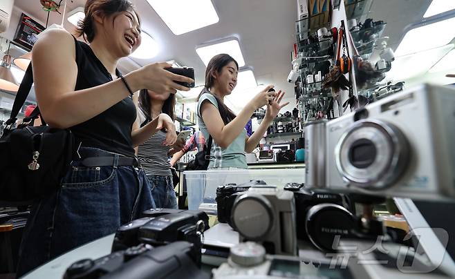 22일 서울 종로구 세운상가 내 중고카메라 매장에서 손님들이 구형 디지털카메라를 살펴보고 있다. 2024.7.22/뉴스1 ⓒ News1 김도우 기자