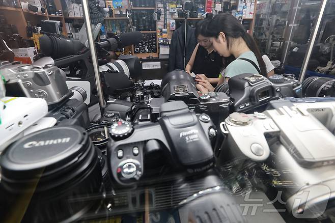 22일 서울 종로구 세운상가 내 중고카메라 매장에서 손님들이 구형 디지털카메라를 살펴보고 있다. 2024.7.22/뉴스1 ⓒ News1 김도우 기자