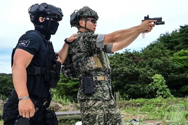 해병대 사령부 직할부대인 특수수색대가 경찰특공대와 함께 경북 포항에 있는 훈련장에서 대테러 합동 사격훈련을 실시했다고 25일 밝혔다. 경찰특공대 요원이 권총 사격술 노하우를 교류하고 있다. (해병대 1사단제공) 2024.7.25/뉴스1