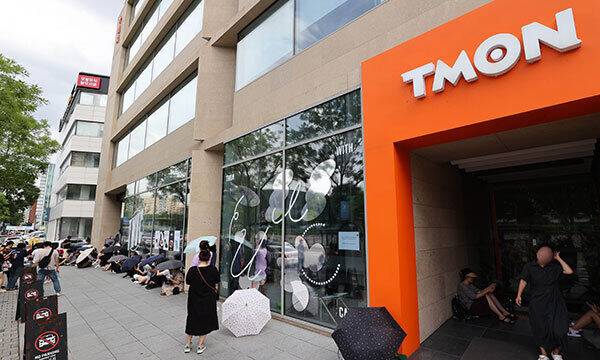 25일 서울 강남구 티몬 본사 앞에서 환불을 원하는 피해자들이 우산을 쓰고 사측을 기다리고 있다. 연합뉴스