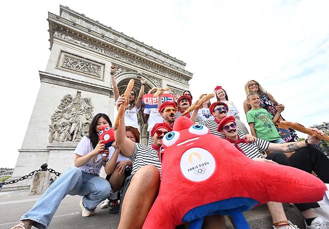 힘내라 대한민국 파리올림픽 개막을 하루 앞두고 주프랑스 한국문화원 직원과 프랑스 문화를 상징하는 마리니에르를 입은 파리 시민들이 파리 개선문 앞에서 한국 팀의 선전을 기원하고 있다. 파리 이충우 기자