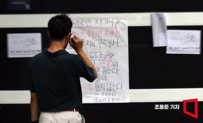 위메프·티몬의 '판매 대금 미정산 사태'가 이어지고 있는 29일 서울 강남구 영동대로 위메프 본사 앞에서 한 시민이 피해자들이 붙인 대자보를 보고 있다.