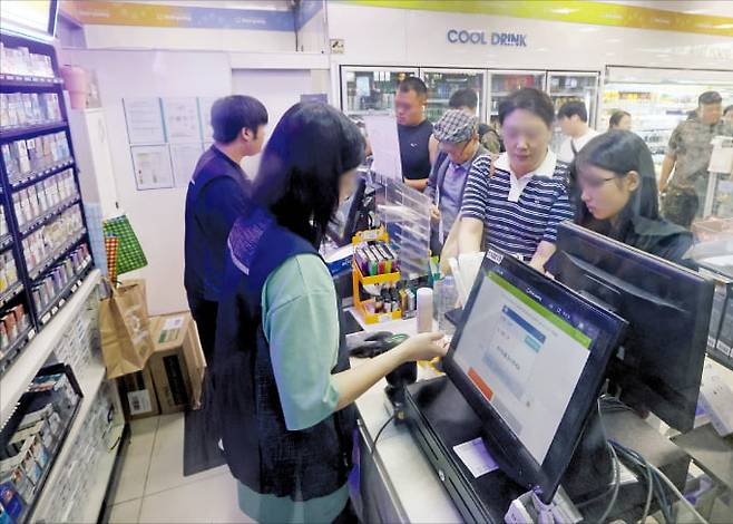정부가 편의점 등 5인 미만 사업장에 근로기준법을 적용하는 방안을 검토하고 있다. 4일 서울역 대기실에 있는 한 편의점에서 직원이 소비자가 고른 물건을 계산하고 있다. 이솔 기자