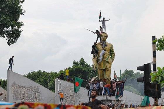 지난 5일 방글라데시 다카에서 셰이크 하시나 총리의 사임을 축하하는 동안 사람들이 초대 대통령의 동상을 훼손하고 있다. 로이터=연합뉴스