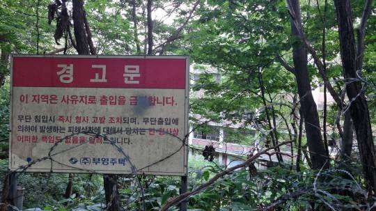 7일 출입 금지 경고문과 윤형철조망 뒤편으로 2005년 폐교된 충일여자고등학교 건물 일부가 보이고 있다. 김민 기자.
