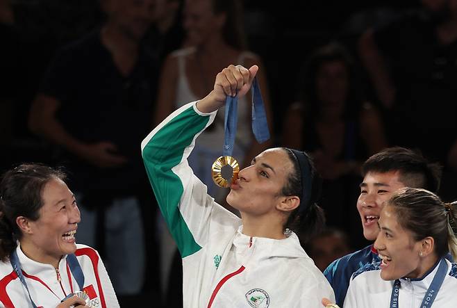 9일(현지시간) 프랑스 파리 롱랑가로스 경기장에서 열린 2024 파리올림픽 복싱 여자 66kg급 결승전에서 성별 논란에 휩싸였던 알제리의 이마네 칼리프가 금메달을 딴 뒤 메달에 입을 맞추고 있다. 함께 경쟁한 선수들도 환하게 웃으며 축하하고 있다. 연합뉴스