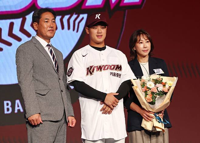 정현우(덕수고·가운데)가 11일 오후 서울 송파구 롯데호텔 월드 크리스탈볼룸에서 열린 2025 KBO 신인 드래프트에서 키움 히어로즈에 1라운드 1순위 지명을 받은 뒤 고형욱 단장(왼쪽)과 어머니와 함께 기념촬영을 하고 있다. 연합뉴스