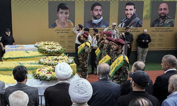 18일(현지시각) 레바논 베이루트 남부 교외에서 헤즈볼라 대원들이 무선호출기 폭발로 숨진 4명의 시신이 든 관을 향해 거수경례하고 있다. AP뉴시스