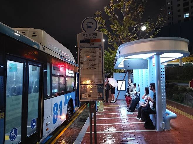 부산진구청 앞 허그 스테이션에서 승객들이 버스를 기다리고 있다. 정류장 그늘로 활용하기 위해 가로수를 살렸다. 김광수 기자