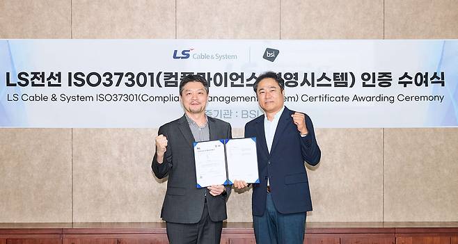 Kim Byeong-ok (left), chief compliance officer of LS Cable & System, and Lim Seong-hwan, CEO of BSI Korea, pose during the certification awarding ceremony at LS C&S headquarters in Anyang, Gyeonggi Province last month. (LS Cable & System)