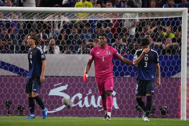 스즈키 자이온(1번)이 제23회 국제축구연맹 월드컵 아시아 예선 출전 6경기 만에 골키퍼 본인 탓이 아닌 동료 자책골로 첫 실점을 했는데도 실수를 저지른 다니구치 쇼고(3번)를 위로해 주고 있다. 사진=Getty Images=연합뉴스 제공