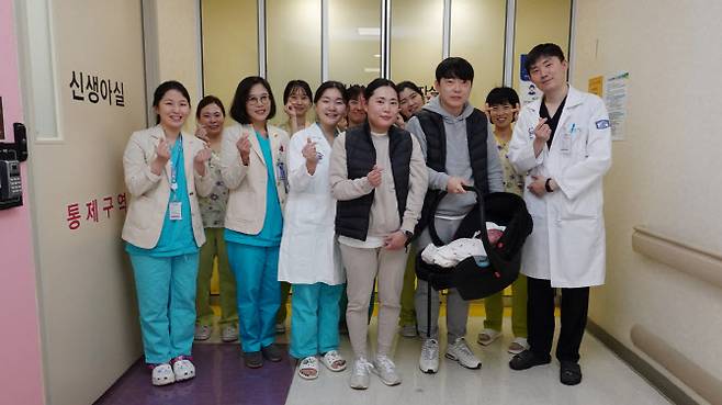 올해 5월 31일 가톨릭대학교 서울성모병원에서 512g의 몸무게로 태어난 예찬이가, 29일 약 5개월의 병원 생활을 마치고 3.68kg의 몸무게로 건강하게 퇴원했다. (오른쪽부터) 오문연 교수, 예찬이와 부모, 김민수 교수,김세연 교수,이희진 신생아중환자실 간호사, 김솔 교수.