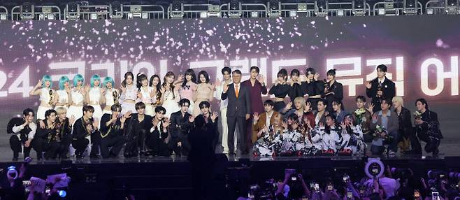 왼쪽 위부터 시계방향으로 그룹 (여자)아이들, 스테이씨, 정동원, 곽재선 KG그룹 회장, 영탁, QWER, 유회승, 태민, 이무진, 피원하모니, 뉴진스, 제로베이스원이 16일 인천 중구 운서동 인스파이어 아레나에서 열린 ‘제1회 코리아 그랜드 뮤직 어워즈’(KGMA) 첫날 아티스트 데이를 마치고 기념 촬영을 하고 있다.(사진=KGMA 특별취재반)