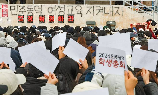 지난 20일 서울 성북구 동덕여대에서 열린 학생총회에서 학생들이 남녀공학 전환 찬반 투표에서 반대표를 들고 있다. 최상수 기자