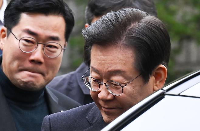 위증교사 혐의 무죄 선고를 받은 이재명 더불어민주당 대표가 25일 서울 서초동 서울중앙지방법원에서 나온 후 차에 타기 전 의원들에게 인사를 하고 있다. ⓒ공동취재단