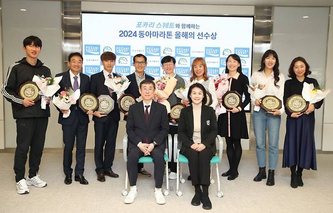 2024 동아마라톤 시상식에서 올해의 선수상을 수상한 최범식 김형락 조우원 김회묵 유문진 노은희 홍서린 지윤아 목영주 씨(뒷줄 왼쪽부터)가 기념촬영을 하고 있다. 앞줄은 천광암 동아일보 논설위원(왼쪽)과 이진숙 동아오츠카 전무. 변영욱 동아일보 기자 cut@donga.com