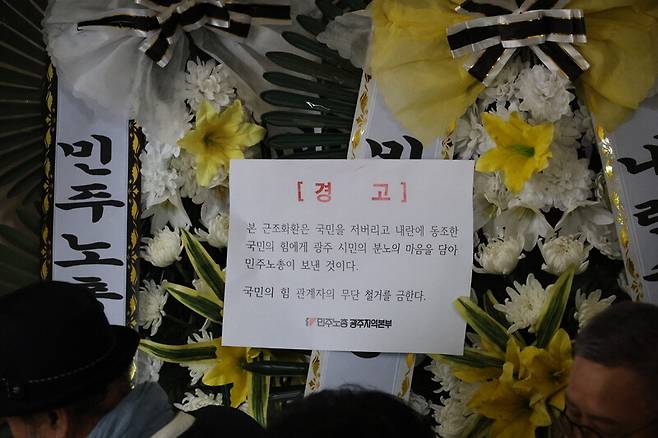 9일 광주광역시 서구 국민의힘 광주광역시당 앞에 민주노총 광주지역본부가 윤석열 대통령 탄핵 투표에 불참한 국민의힘 의원들을 비판하는 근조화환을 놓으며 무단 철거에 대한 경고문을 써붙여 놓았다. 민주노총 광주지역본부 제공