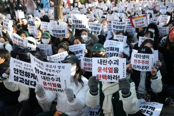윤석열 대통령에 대한 국회 탄핵안 표결일인 지난 7일 서울 여의도에서 열린 '윤석열 퇴진 대학생 시국대회'에 참가한 학생들이 손팻말을 들고 있다. 뉴스1