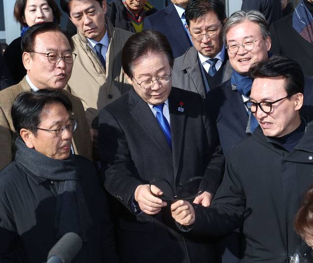 이재명 더불어민주당 대표 지난 4일 국회 본청 앞에서 계엄군이 놓고 간 수갑을 살펴보고 있다. 연합뉴스