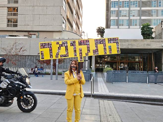 10일 이스라엘 텔아비브 법원에서 노란색 옷을 입은 반(反)네타냐후 시위 참가자가 팻말을 들고 침묵 시위를 벌이고 있다./김지원 특파원