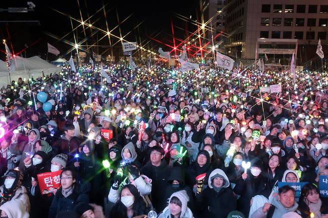 윤석열 대통령 탄핵소추안이 가결된 14일 서울 여의도 국회 앞에서 열린 윤 대통령 탄핵 촉구 집회에 참가한 시민들이 기뻐하며 노래를 따라부르고 있다. /연합뉴스