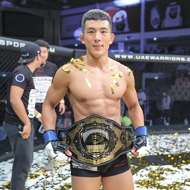 이도겸이 2019년 10월 UFC 출신 롤란도 디를 제압하여 UAEW 페더급 챔피언으로 등극한 후 기념 촬영을 하고 있다. 사진=UAE Warriors