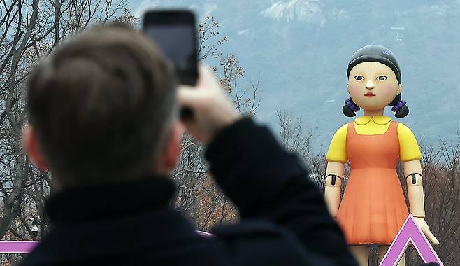 사진은 서울 종로구 광화문광장에서 한 외국인 관광객이 넷플릭스 '오징어게임2' '영희'의 대형 모형을 스마트폰으로 촬영하는 모습. /뉴스1