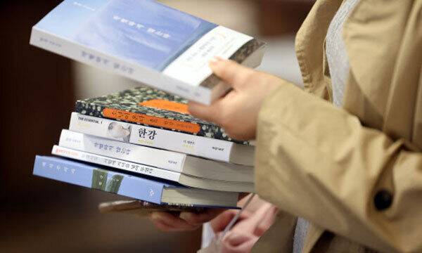 서울 종로구 교보문고 광화문점에서 한 시민이 노벨문학상을 수상한 소설가 한강의 책을 구매하고 있다. 연합뉴스