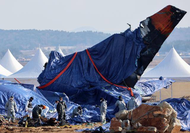 제주항공 여객기 참사 11일째인 8일 오전 전남 무안국제공항에서 관계자들이 꼬리 날개 주변에서 수습 작업을 하고 있다. 무안=연합뉴스