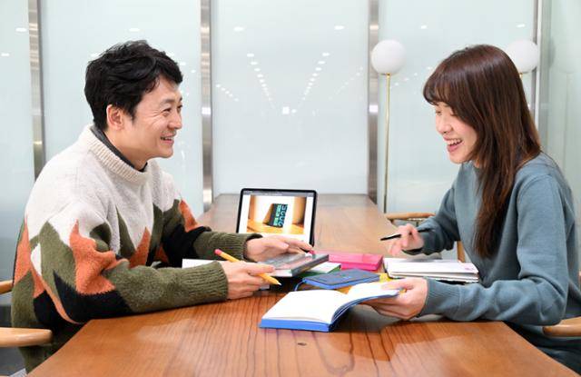 정기열(왼쪽) 서울시 홍보담당관 주무관과 오제윤 총무과 주무관이 '서울플래너 2025'를 보며 이야기를 나누고 있다. 서울시 제공