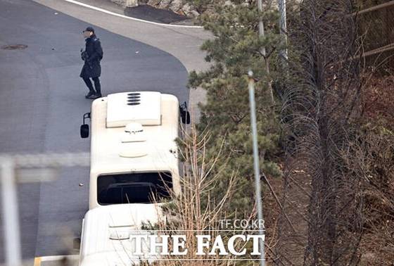 13일 서울 한남동 대통령 관저에서 한 경호처 관계자가 소총을 지닌 채 경내를 이동하고 있다. 사진 더팩트