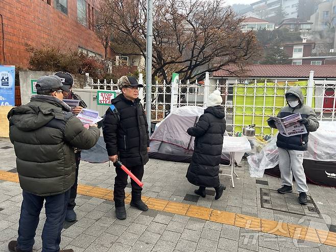 14일 서울 용산구 한남동에서 열린 탄핵 반대 집회 참가자들이 부정 선거를 주장하는 전단을 들여다보고 있다. 2025.01.14/뉴스1 ⓒ 뉴스1 김민재 기자