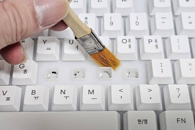 키캡 아래에 있는 이물질은 ▲칫솔 ▲붓 등을 활용해 청소합니다. 기판 안으로 이물질이 들어가지 않도록 입구를 미리 막아두면 도움이 됩니다 / 출처=IT동아