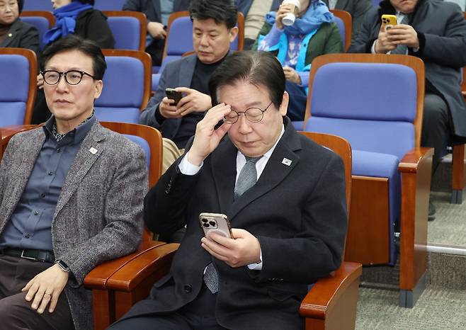 더불어민주당 이재명 대표가 19일 국회에서 열린 비상의원총회에 입장해 휴대폰을 살펴보고 있다. 연합뉴스