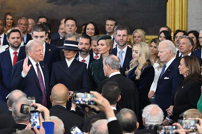 도널드 트럼프 미국 대통령 당선인이 부인 멜라니아 여사, 가족과 함께 20일(현지 시간) 미 워싱턴 연방의회 의사당 로툰다 홀에서 취임 선서를 하고 있다. ⓒ AFP=뉴스1 ⓒ News1 김진환 기자