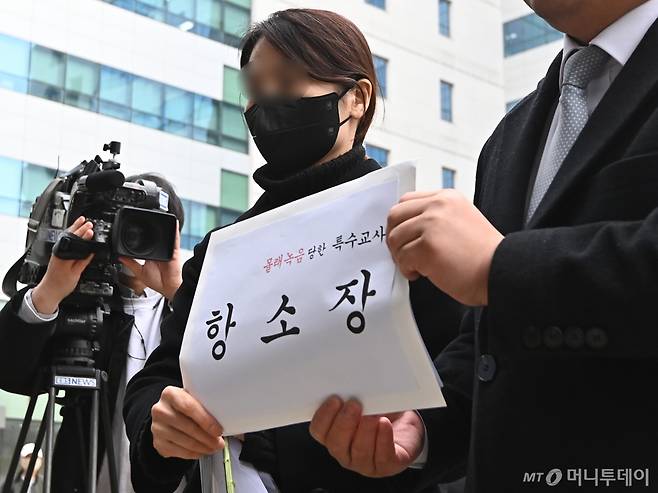 웹툰 작가 주호민씨의 자폐 스펙트럼 아들을 정서적으로 학대한 혐의로 1심에서 유죄 판단을 받은 특수교사 A씨가 지난해 2월 6일 경기 수원지방법원에서 항소장을 제출하기 위해 법원 민원실을 들어서는 모습./사진=뉴시스