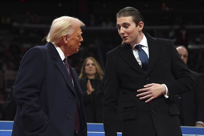 도널드 트럼프 대통령이 20일(현지시간) 워싱턴의 캐피털 원 아레나에서 열린 실내 대통령 취임 퍼레이드 행사에 참석해 막내아들 배런과 얘기하고 있다. AP/뉴시스