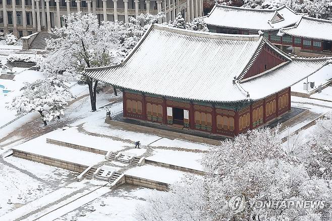 눈 내린 덕수궁 (서울=연합뉴스) 김성민 기자 = 눈이 내린 27일 오전 서울 중구 덕수궁에서 관계자가 눈을 치우고 있다. 2024.11.27 ksm7976@yna.co.kr