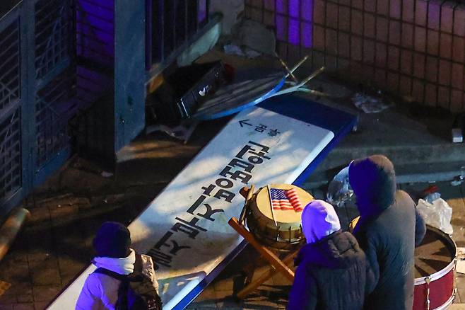 내란 우두머리 혐의를 받는 윤석열 대통령의 구속영장이 발부된 지난 19일 오전 서울 마포구 서울서부지방법원 후문에서 윤 대통령 지지자들이 부순 현판이 놓여 있다. 이들은 이날 오전 3시쯤 윤 대통령 구속영장 발부 소식이 전해지자 극도로 흥분해 법원 후문에서 경찰 저지를 뚫었다. 연합뉴스